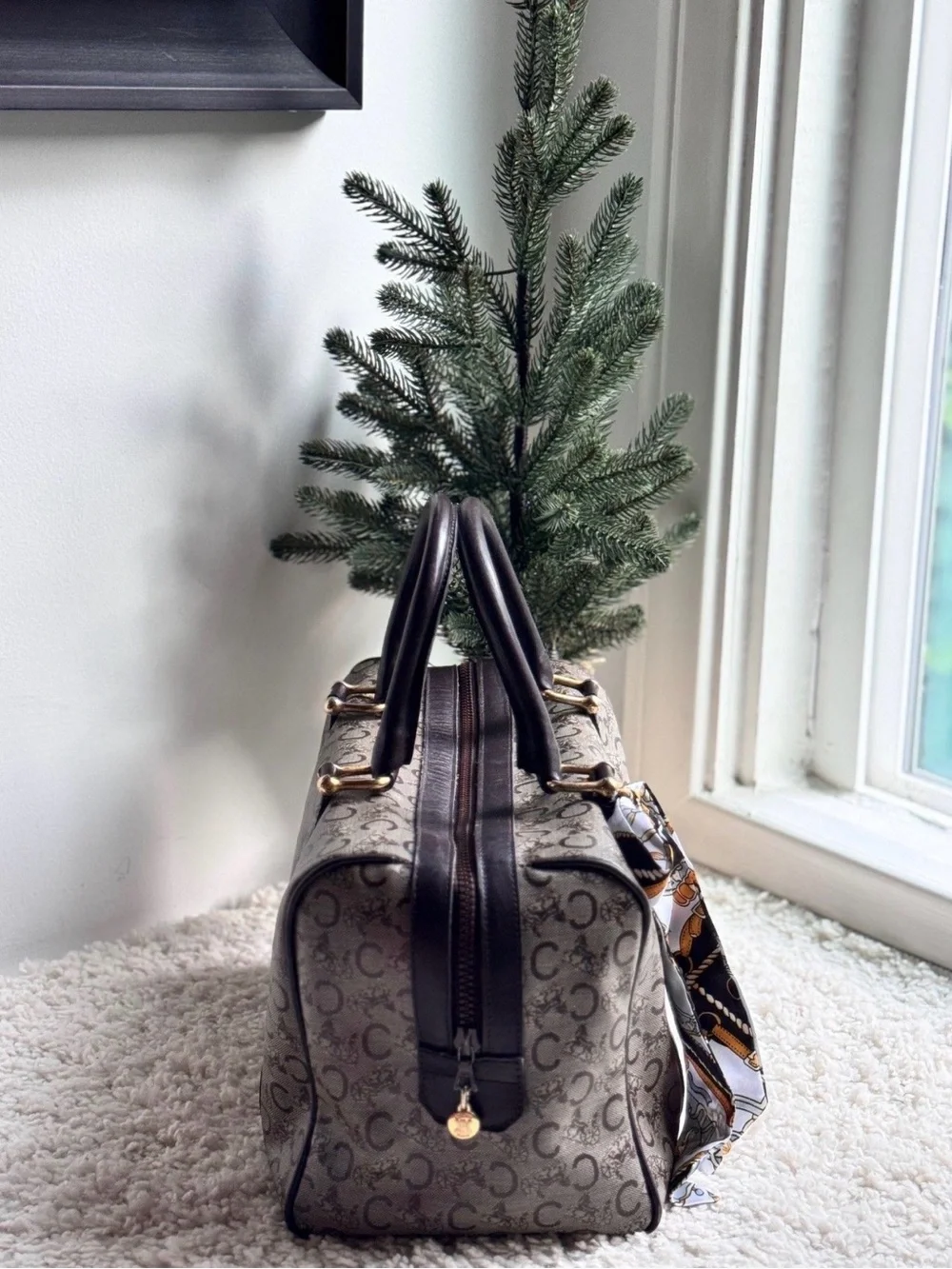Celine Boston bag features the iconic Macadam monogram pattern and leather trim.